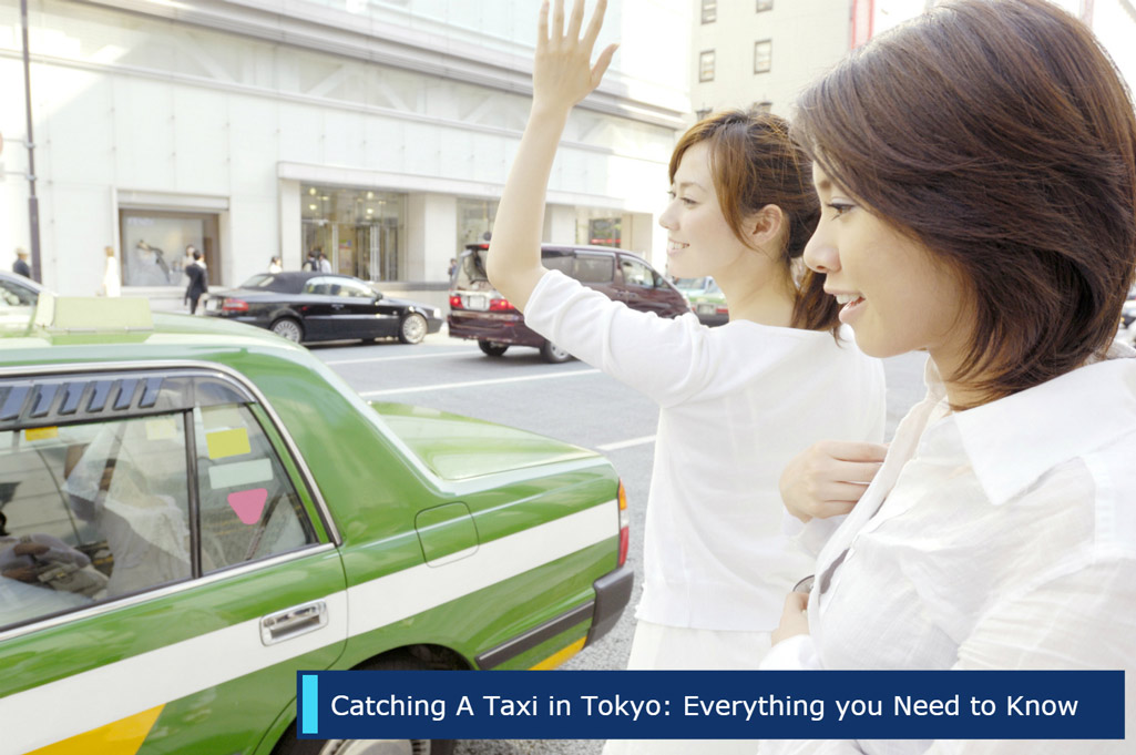 Two women hailing a taxi at a taxi stand.